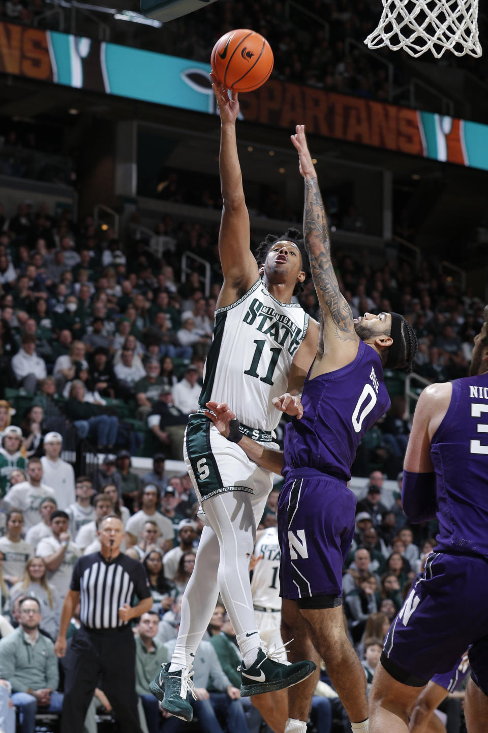 Michigan State's A.J. Hoggard, left, shoots against Northwestern's Boo Buie during the first half of an NCAA college basketball game, Sunday, Dec. 4, 2022, in East Lansing, Mich. (AP Photo/Al Goldis)