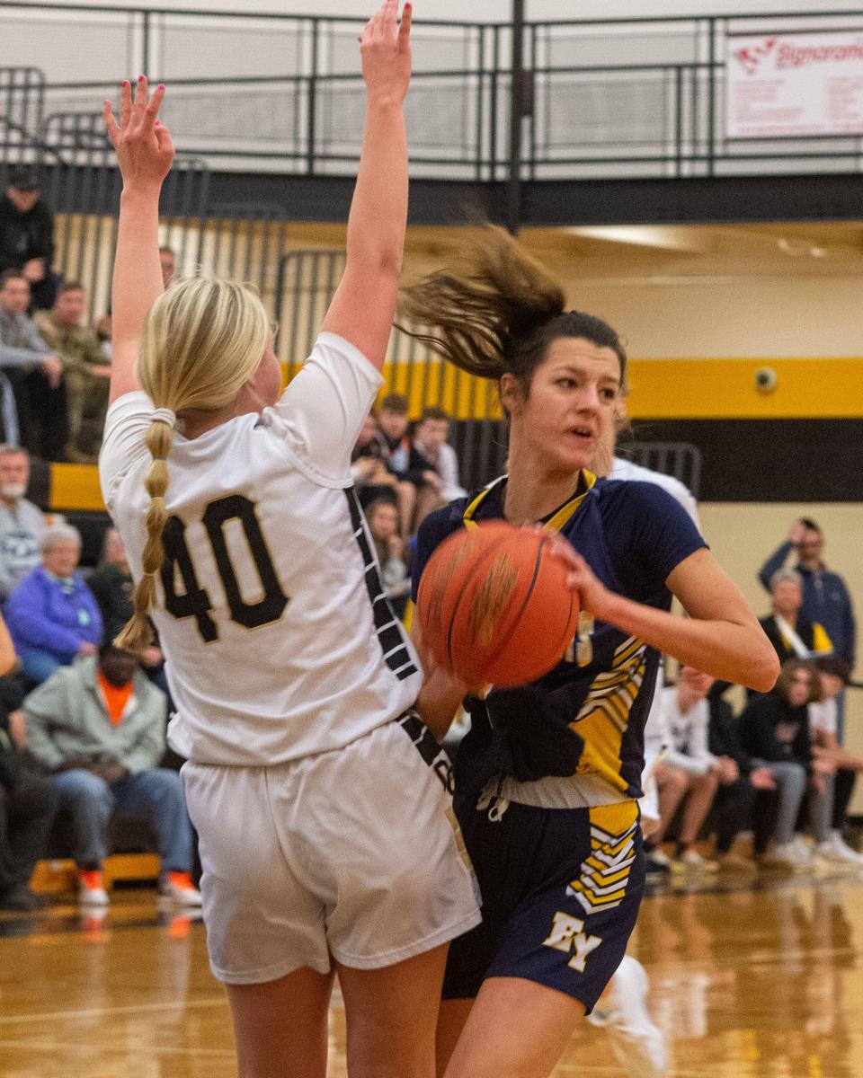 Eastern York’s Arianna Seitz looks to pass the ball after running into the defense of Delone Catholic’s Kaitlyn Schwarz on Saturday, Feb. 11, 2023 at Red Lion High School. Delone won the YAIAA quarterfinal 50-33.