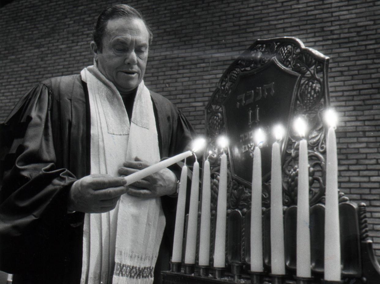 Rabbi Albert A. Goldman of Isaac M. Wise Temple lights the eight candles of the menorah in 1979.