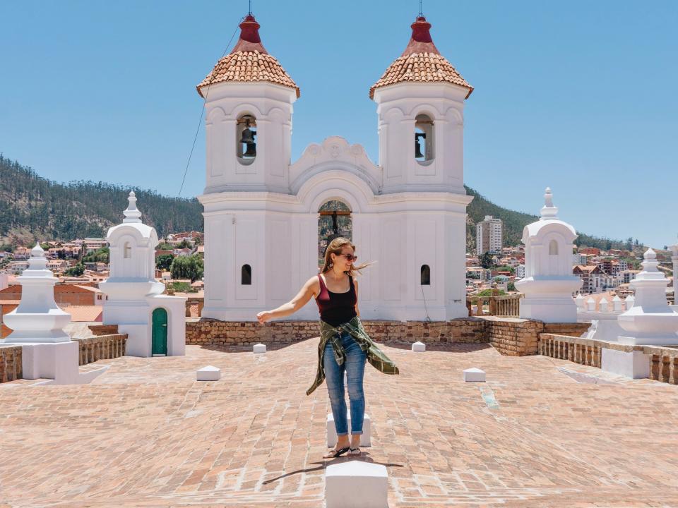 nicole jones (writer) standing in front of white building with sky in the background