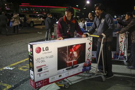 Shoppers leave the Best Buy electronics store with purchases on the Thanksgiving Day holiday in Westbury, New York, November 28, 2013. REUTERS/Shannon Stapleton