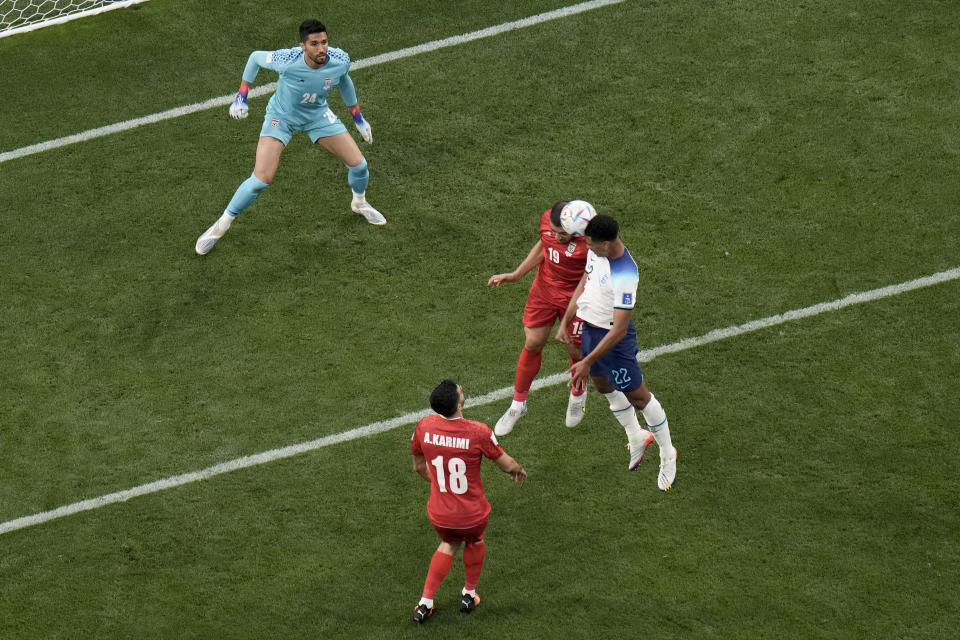 England's Jude Bellingham, right, scores his side's opening goal during the World Cup group B football match between England and Iran at the Khalifa International Stadium in Doha, Qatar, Monday, Nov. 21, 2022. (AP Photo/Hassan Ammar)