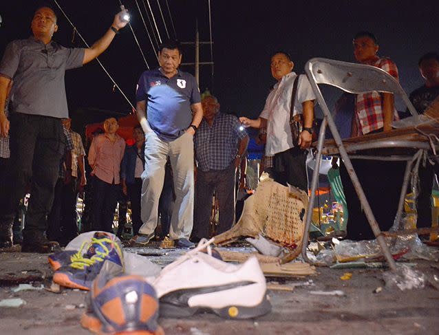 Philippine President Rodrigo Duterte, second left, visits the site of Friday night's explosion that killed more than a dozen people and wounded several others at a night market in Davao city, his hometown. Photo: AP