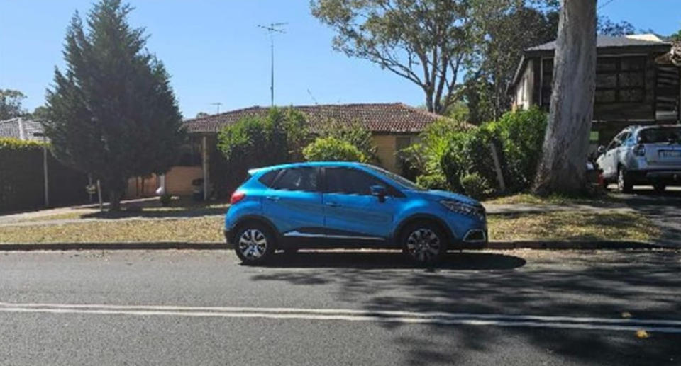 Blue car parked near double lines on Sydney street before parking fine. 