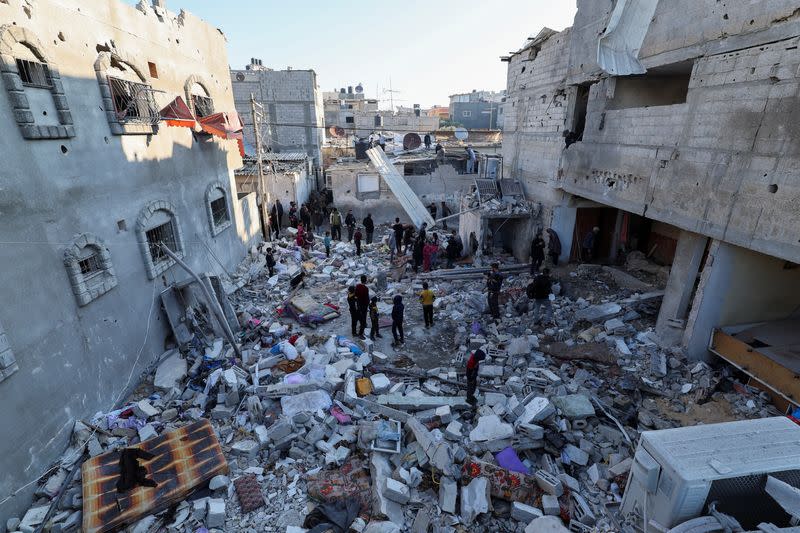 Palestinos inspeccionando el lugar de un ataque israelí contra una casa, en Ráfah