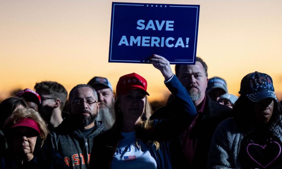 woman holding sign saying ‘Save America’