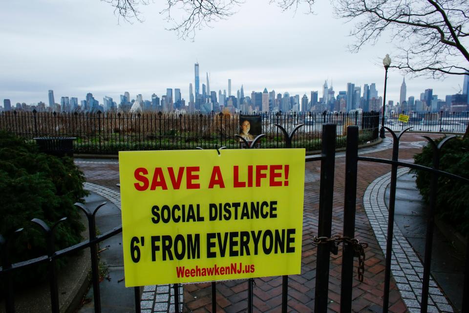 A sign encouraging social distancing to stop the spread of coronavirus is displayed at a closed park in Weehawken, New Jersey, on Saturday. (Photo: KENA BETANCUR via Getty Images)