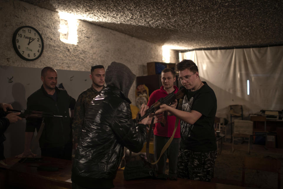 Daniel, a la derecha, un ucraniano de 16 años, recibe entrenamiento sobre el manejo de armas y otras habilidades de combate durante un evento de capacitación para voluntarios que se unen a las Fuerzas de Defensa Territorial en Leópolis, Ucrania, el jueves 26 de mayo de 2022. (Diego Ibarra Sanchez/The New York Times)
