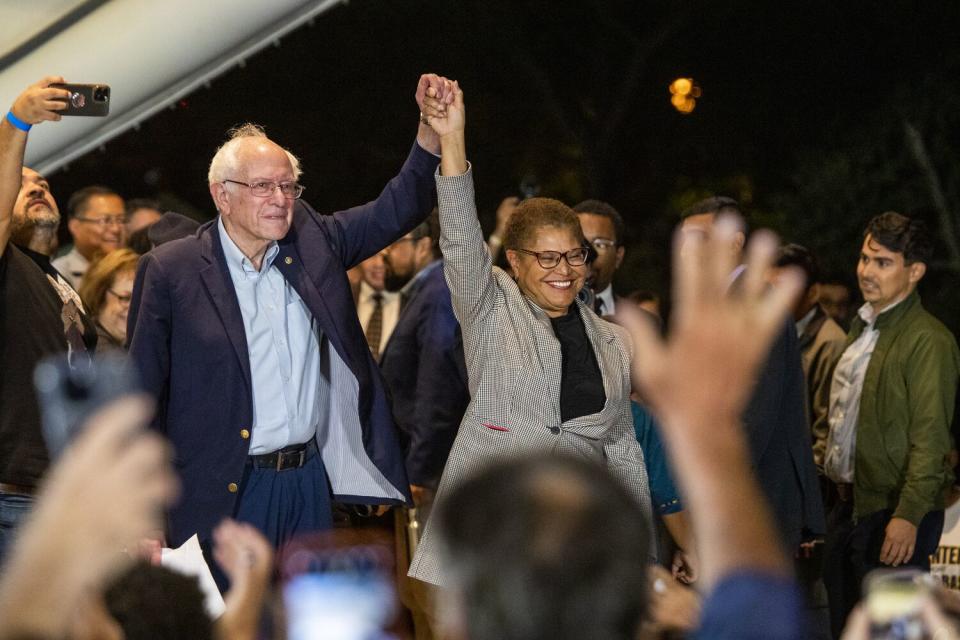 Vermont Sen. Bernie Sanders joins hands with Karen Bass at her mayoral campaign event.