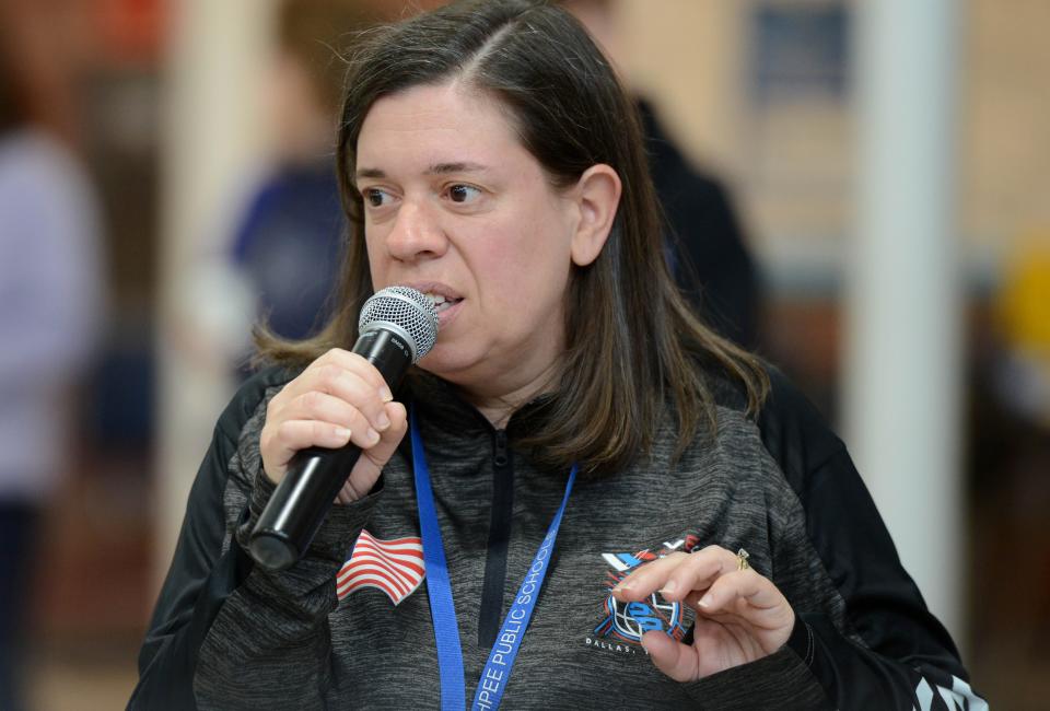 Mashpee Middle-High School technology and engineering teacher Amanda Hough introduces teams on Saturday during a regional robotics competition at the school.