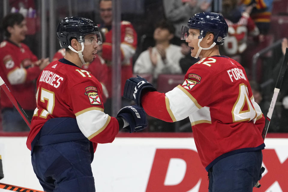Florida Panthers defenseman Gustav Forsling (42) is congratulated by center Evan Rodrigues (17) after scoring a goal during the second period of an NHL hockey game against the Vegas Golden Knights, Saturday, Dec. 23, 2023, in Sunrise, Fla. (AP Photo/Lynne Sladky)