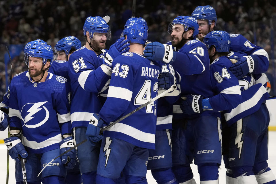 Tampa Bay Lightning defenseman Darren Raddysh (43) celebrates with teammates after scoring the game-winning goal against the New Jersey Devils during overtime in an NHL hockey game Thursday, Jan. 11, 2024, in Tampa, Fla. (AP Photo/Chris O'Meara)