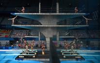 <p>A picture shows the reflection of the boards as divers warm up ahead of a diving session during the Tokyo 2020 Olympic Games at the Tokyo Aquatics Centre in Tokyo on July 27, 2021. (Photo by Oli SCARFF / AFP)</p> 