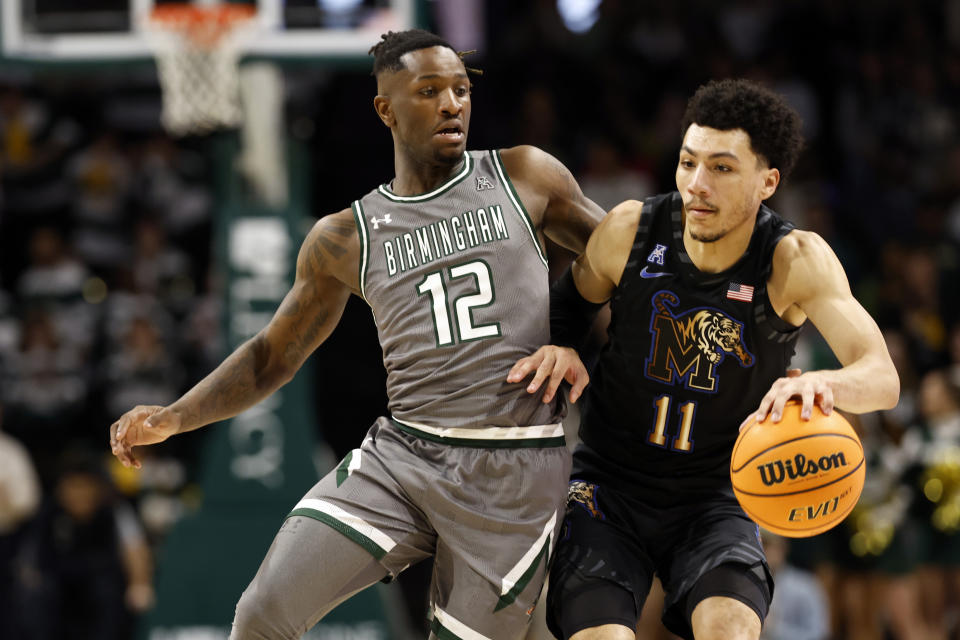 Memphis guard Jahvon Quinerly (11) dribbles around UAB guard Tony Toney (12) during the first half of an NCAA college basketball game, Sunday, Jan. 28, 2024, in Birmingham, Ala. (AP Photo/Butch Dill)