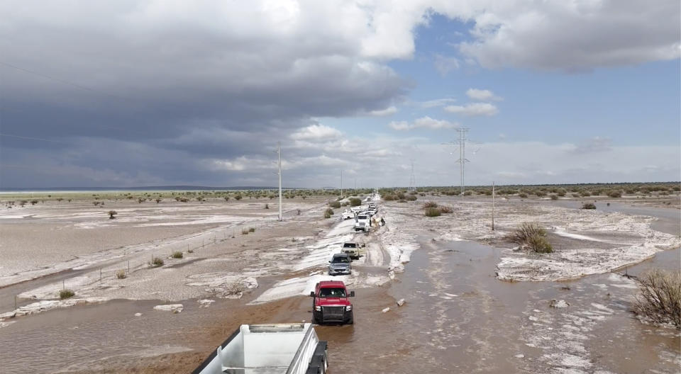 In this photo provided by Mike Bischoff, Vehicles are lined up after flash flooding along Highway 42 near Willard, N.M., on Wednesday, June 19, 2024. (Mike Bischoff @blueskyproductionsutah via AP)