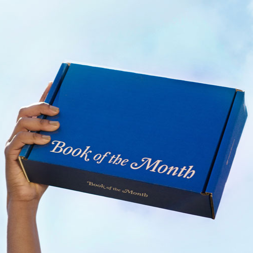 Hand holding up a Book of the Month Subscription Box