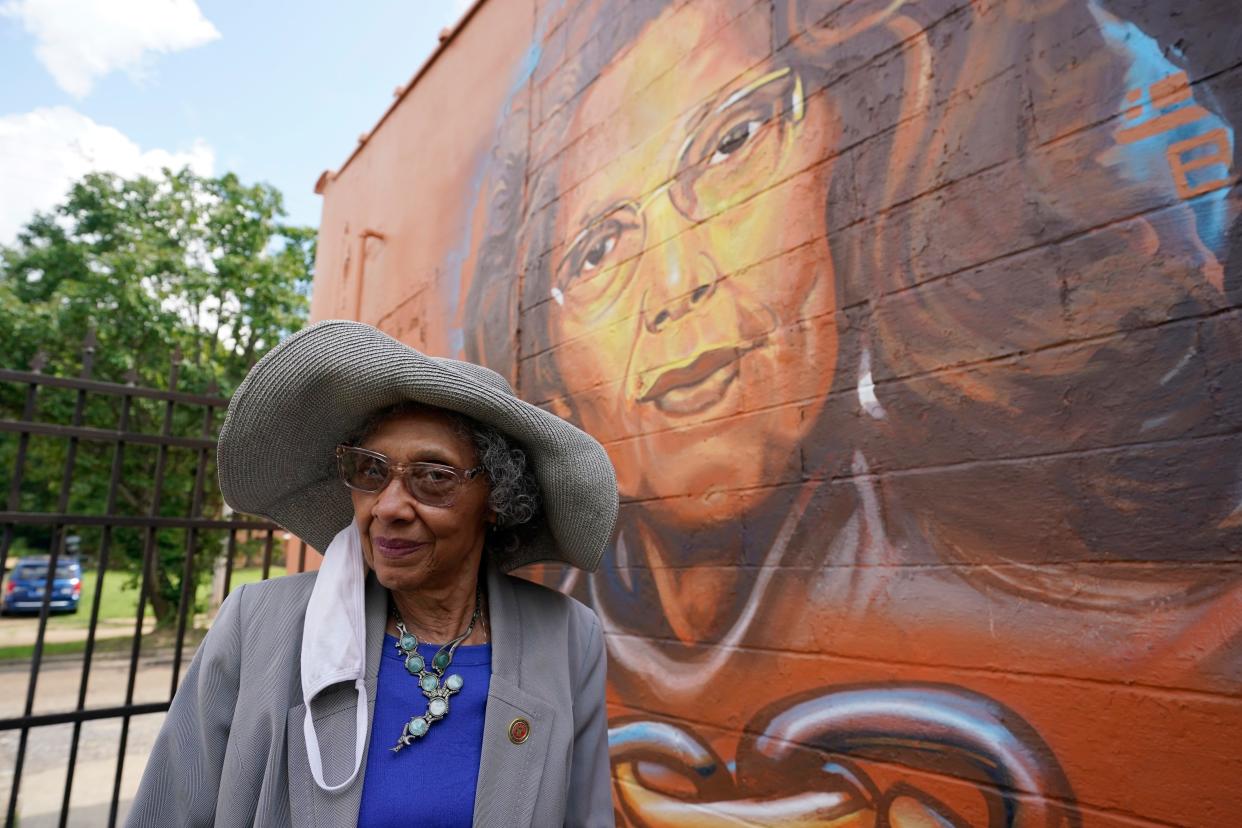 State Rep. Alyce Clarke, D-Jackson, stands along side the mural painted on the COFO building honoring six civil rights legends, living and dead, that the Jackson State University's Office of Community Engagement, honored during the unveiling of its "Chain Breakers" mural in Jackson, Miss., Saturday, July 24, 2021. (AP Photo/Rogelio V. Solis)