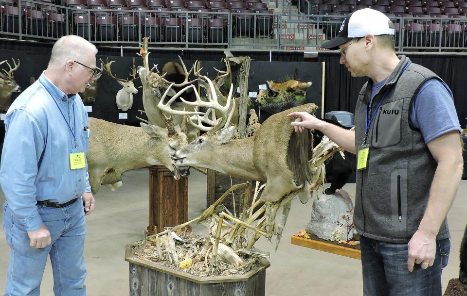 Ray Kowalski, left, and Jens Jorgensen of the Pennsylvania Taxidermist Association, look at a mount of two bucks sparring during the 2023 competition at the Kovalchick Convention and Athletic Complex in Indiana, Pa.