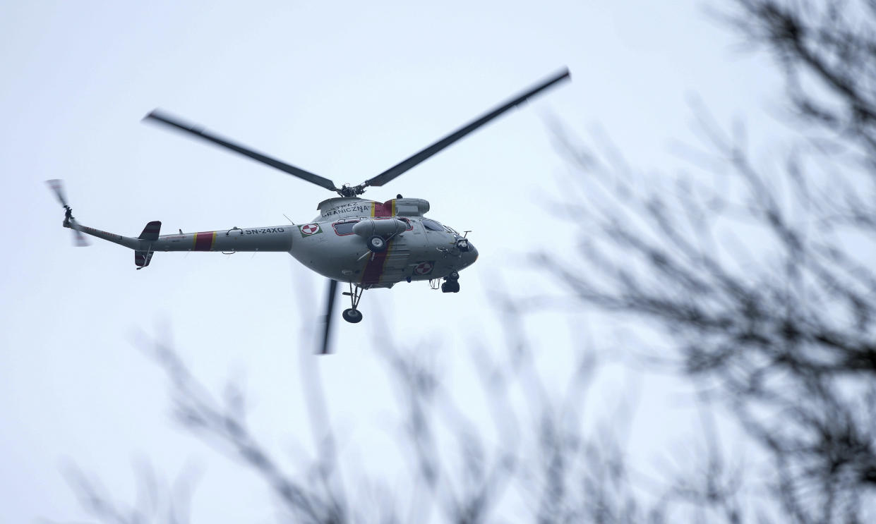 A helicopter of the 'Polish Border Guard' flies next to a check point close to the border with Belarus in Kuznica, Poland, Tuesday, Nov. 16, 2021. (AP Photo/Matthias Schrader)