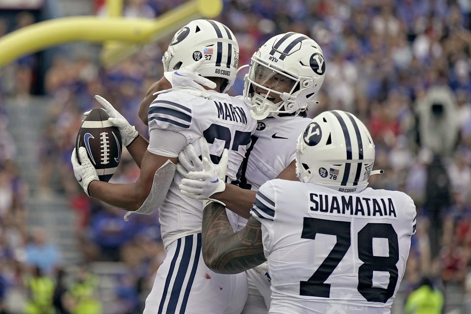 BYU running back LJ Martin (27) celebrates with teammates after scoring a touchdown during the first half of an NCAA college football game against Kansas Saturday, Sept. 23, 2023, in Lawrence, Kan. | Charlie Riedel, Associated Press