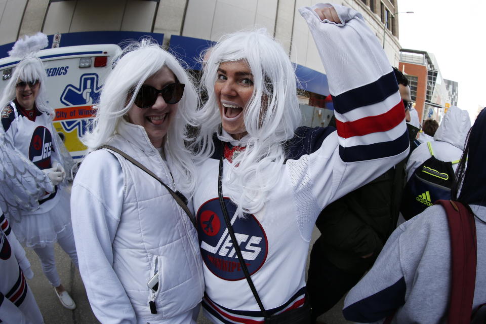 Fans Melinda Sellwood and Nicole Kjartanson gather for the Winnipeg Jets White Out Party prior to Game 1 of an NHL hockey first-round playoff series against the St. Louis Blues, Wednesday, April 10, 2019, in Winnipeg, Manitoba. (John Woods/The Canadian Press via AP)