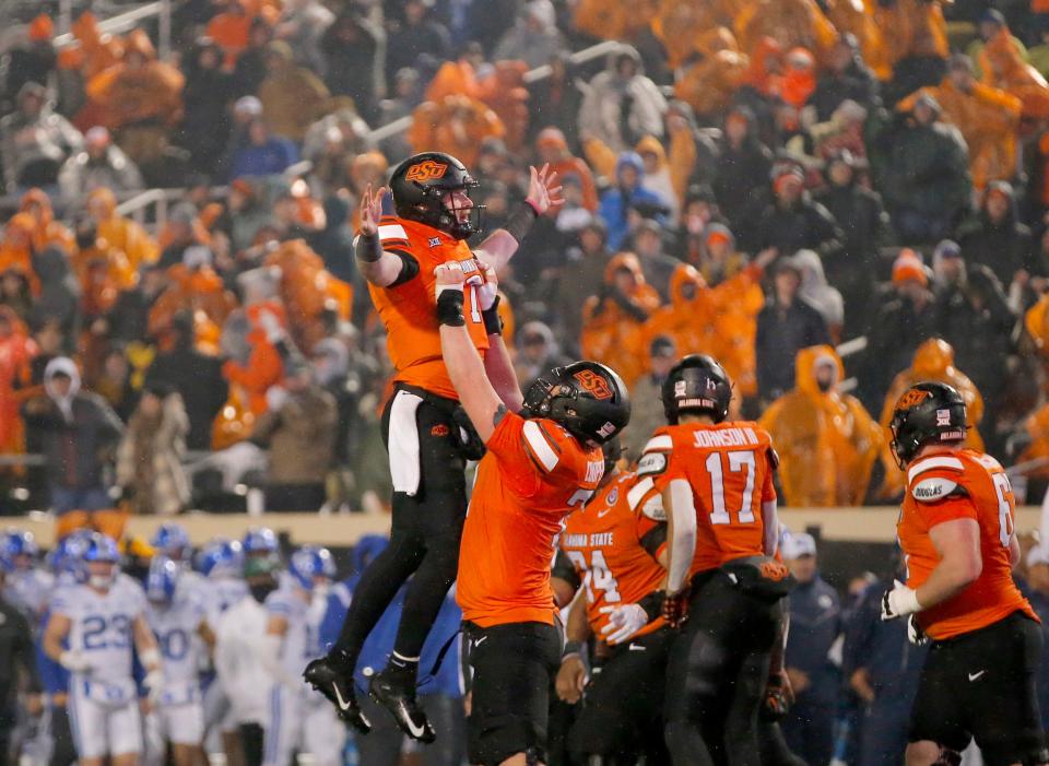 Nov 25, 2023; Stillwater, Oklahoma, USA; Oklahoma State's Alan Bowman (7) celebrates with Dalton Cooper (71) following a touchdown during second half of the college football game between the Oklahoma State University Cowboys and the Brigham Young Cougars at Boone Pickens Stadium. Mandatory Credit: Sarah Phipps-USA TODAY Sports