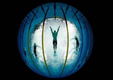 Michael Phelps (C) of the U.S. swims the butterfly stroke during his team's victory in the men's 4x100 meters medley relay at the National Aquatics Center during the Beijing 2008 Olympics in China August 17, 2008. REUTERS/Wolfgang Rattay