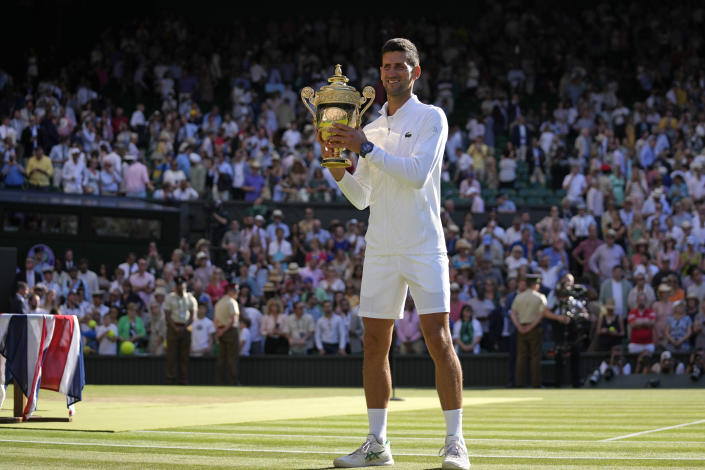 Serbia's Novak Djokovic holds the winners trophy as he celebrates after beating Australia's Nick Kyrgios to win the final of the men's singles on day fourteen of the Wimbledon tennis championships in London, Sunday, July 10, 2022. (AP Photo/Alastair Grant)