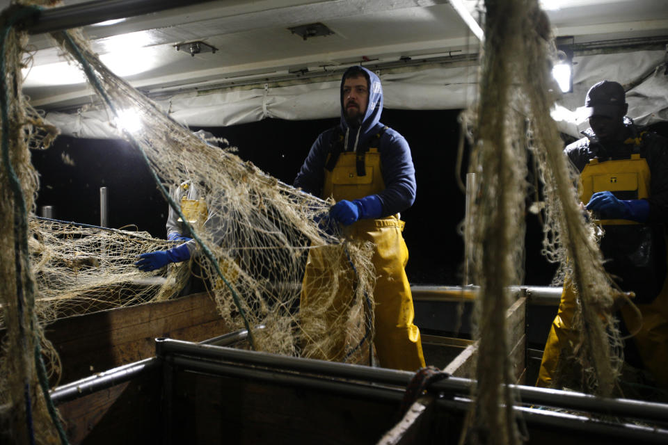 FILE - In this Thursday, Dec. 10, 2020 file photo, fisherman Nicolas Bishop works on the Boulogne sur Mer based trawler "Jeremy Florent II" in Boulogne-sur-Mer, northern France. The European Council adopted Tuesday, Sept. 28, 2021 a euro 5 billion (US dollar 5.8 billion) reserve aimed at helping businesses tackle the short-term negative effects of Brexit. Britain's departure has affected many parts of the EU economy, with the fishing sector particularly at risk. According to the European Commission, EU fisheries face a 25 percent reduction of their catch value in UK waters. (AP Photo/Michel Spingler, File)