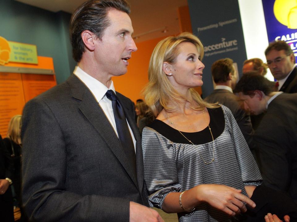 Gavin Newsom and Jennifer Siebel Newsom stand next to each other.