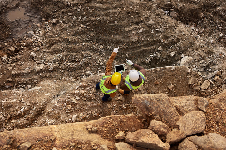 Two miners surveying a mine.