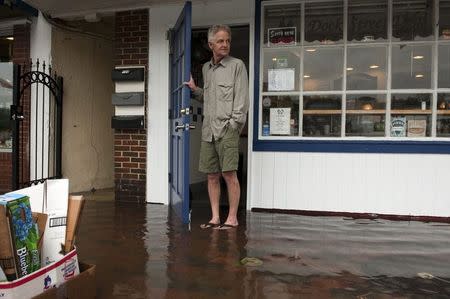 Michael O'Brien, manager of "Pip's Dock Street Dogs," looks out the doorway of his flooded restaurant after the Chesapeake Bay overflowed its banks at City Dock in Annapolis May 16, 2014. Picture taken May 16, 2014. REUTERS/Mary F. Calvert