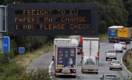 Vehicles pass beneath a sign warning of possible changes to freight procedures following Brexit on the M56 motorway near Chester, Britain