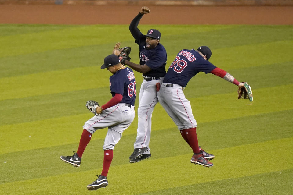 Boston Red Sox left fielder Yairo Munoz, left, center fielder Jackie Bradley Jr., center, and right fielder Alex Verdugo, right, celebrate after a baseball game against the Miami Marlins, Tuesday, Sept.15, 2020, in Miami. (AP Photo/Lynne Sladky)