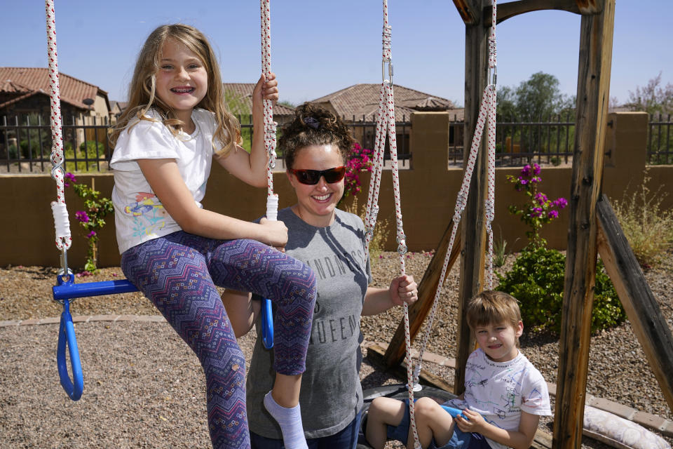 Christie Black, middle, with her two children, Angela and Luke, pose for a photo at their home Tuesday, May 11, 2021, in Mesa, Ariz. The students, a third grader and a kindergartner, attend a school where mask wearing is optional. (AP Photo/Ross D. Franklin)