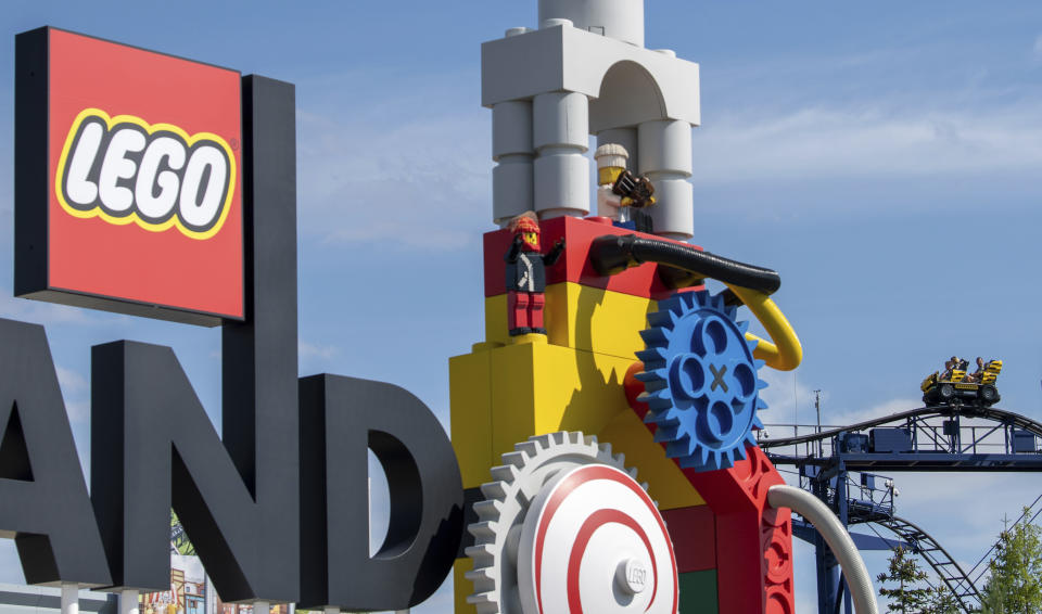 A roller coaster can be seen next to the logo at the entrance to the 'Legoland' amusement park in Guenzburg, southern Germany, Thursday, Aug. 11, 2022. At least 34 people were injured in the accident on a roller coaster at Legoland in Guenzburg, two of them seriously. (Stefan Puchner/dpa via AP)