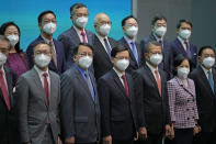 Hong Kong Chief Executive John Lee, bottom center, lines up with his new members of cabinet during a news conference in Hong Kong, Tuesday, July 5, 2022. Lee said Tuesday in his first news conference since taking the reins that he will work towards legislating easing restrictions for travelers, but that it must be balanced with limiting the spread of the coronavirus so as not to overwhelm the healthcare system. (AP Photo/Kin Cheung)