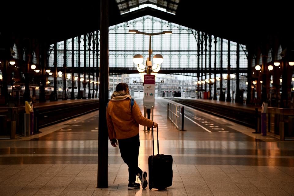 A traveler waits in front of platforms at Gare du Nord train station in Paris on March 23, 2023.