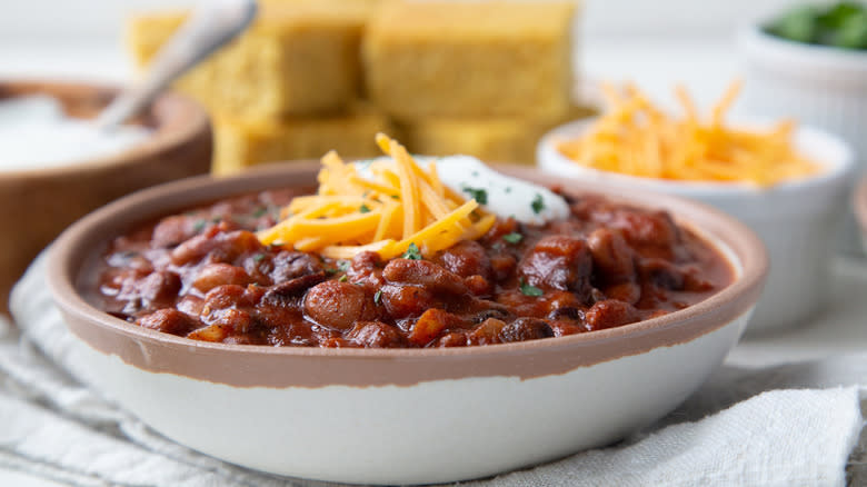 bowl of bean chili topped with cheese and sour cream