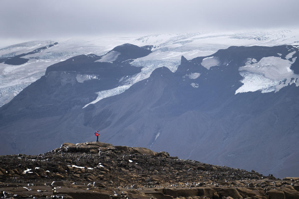 A man stops on his way to the top of what once was the Okjokull glacier, in Iceland, Sunday, Aug. 18, 2019. With poetry, moments of silence and political speeches about the urgent need to fight climate change, Icelandic officials, activists and others bade goodbye to the first Icelandic glacier to disappear. (AP Photo/Felipe Dana)