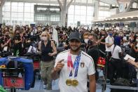 FILE - Italy's Lamont Marcell Jacobs shows the gold medals he won in the men's 100mt and 4x100 relay as he checks in at the Tokyo Haneda airport on his way back to Italy at the end of 2020 Summer Olympics, Monday, Aug. 9, 2021, in Tokyo, Japan. This year could be more memorable for Jacobs than his breakout 2021 when he sprinted from virtual unknown to Olympic 100-meter champion then added another surprising gold at the Tokyo Games with Italy's 4x100-meter relay team. Jacobs tells The Associated Press that "winning these next two big events would mean winning everything there is to win in athletics." (AP Photo/Luca Bruno, File)