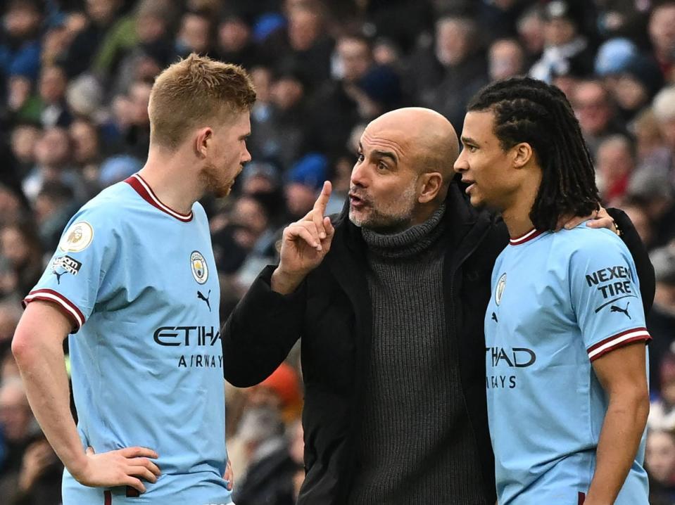 Pep Guardiola speaks with Kevin De Bruyne and Nathan Ake (AFP via Getty Images)