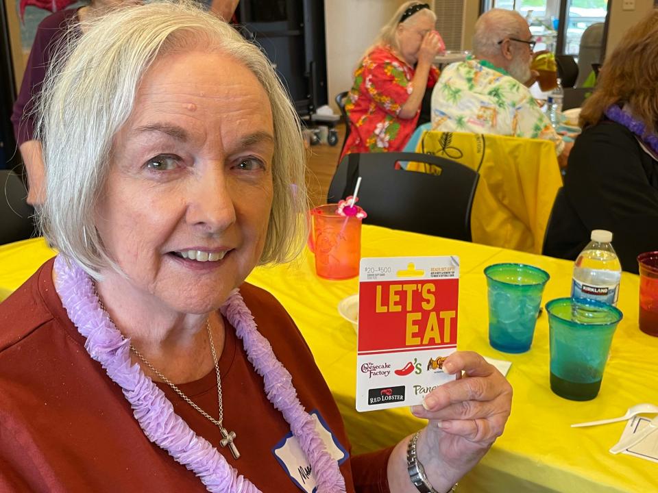 Mary Flanders wins a $100 gift card to the restaurant of her choice from Patriot Homecare at the luau at Karns Senior Center Tuesday, June 7, 2022.