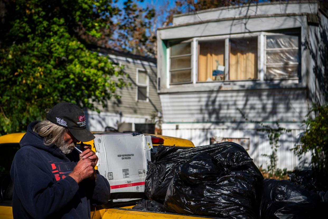 Larry Clay lights a cigarette as he prepares to be evicted from his trailer in Arlington Valley Mobile Home Park on Nov. 2, 2023.