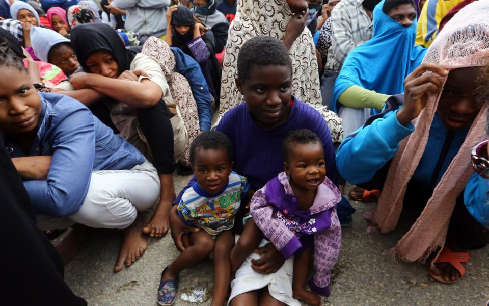 African migrants sit at a gathering at the Tripoli branch of the Anti-Illegal Immigration Authority, in the Libyan capital - Credit: AFP