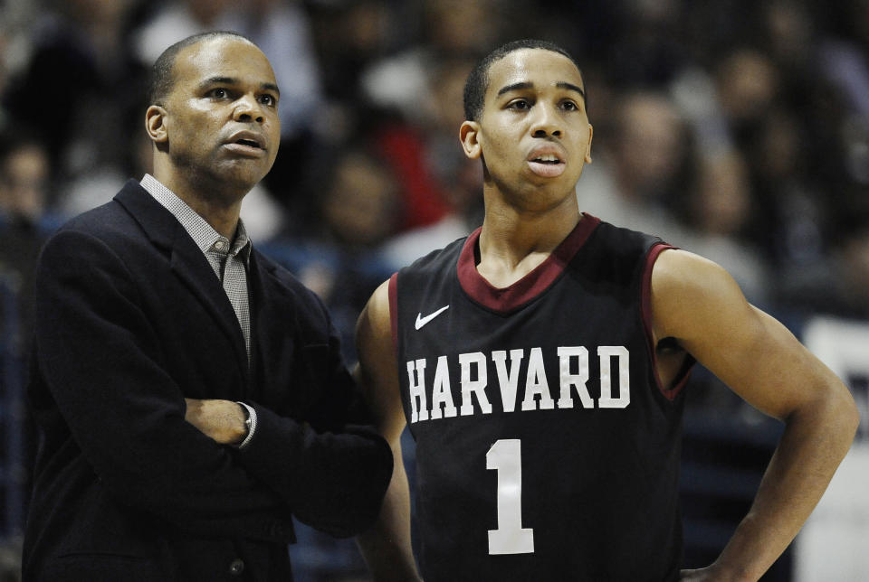 Harvard head coach Tommy Amaker, left, talks with player Siyani Chambers during the first half of an NCAA college basketball game, Friday, March 7, 2014, in New Haven, Conn. (AP Photo/Jessica Hill)