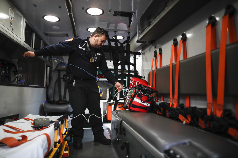 In this April 23, 2020, photo FDNY paramedic Alex Tull, who has recently recovered from COVID-19, prepares to begin his shift outside EMS station 26, the "Tinhouse", in the Bronx borough of New York. (AP Photo/John Minchillo)