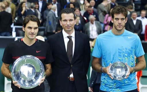 Switzerland's Roger Federer (L) holds the trophy after winning the ABN AMRO Tennis Tournament against Argentina's Martin del Potro (R) in Rotterdam. Federer won the final 6-1, 6-4 against Juan Martin de Potro of Argentina