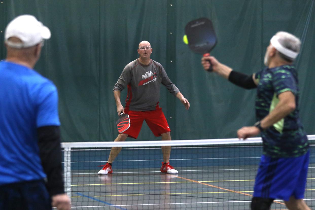 Brent Mason waits for Gary Lanoux to return his serve during a recent pickleball match at Kids American in Coshocton.