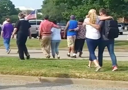 Evacuees walk away from a building in this still image taken from video following a shooting incident at the municipal center in Virginia Beach